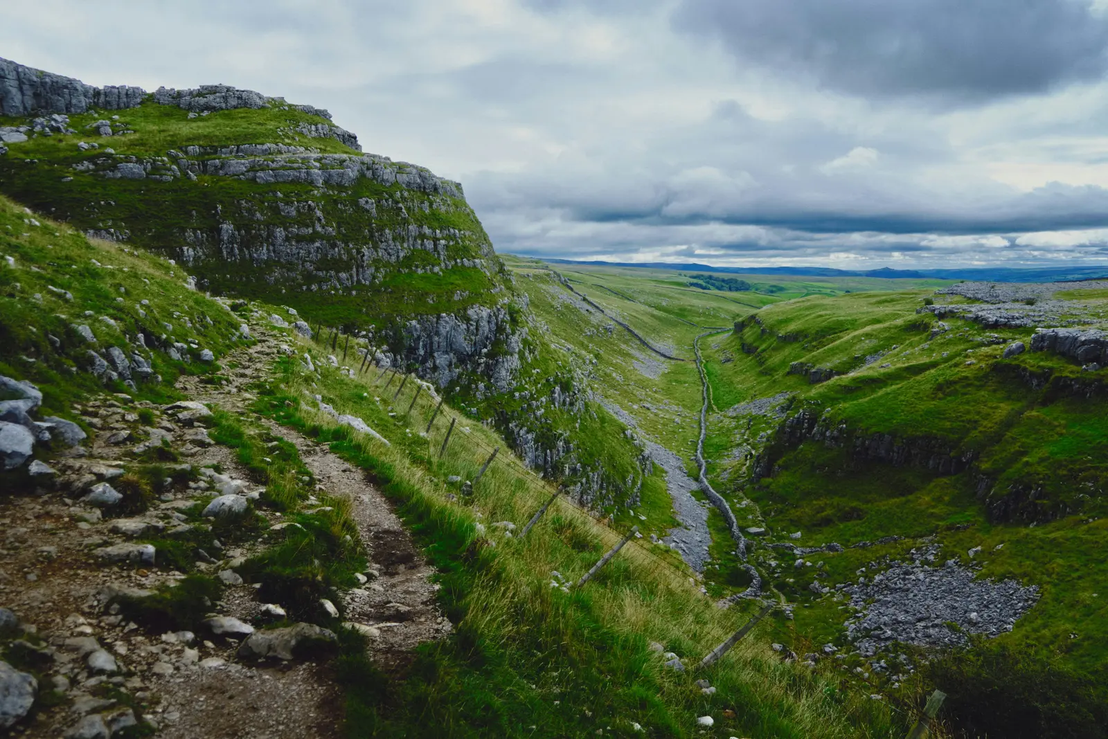 Looking down the valley above Gordale Scar, with a stream running between dry stone walls