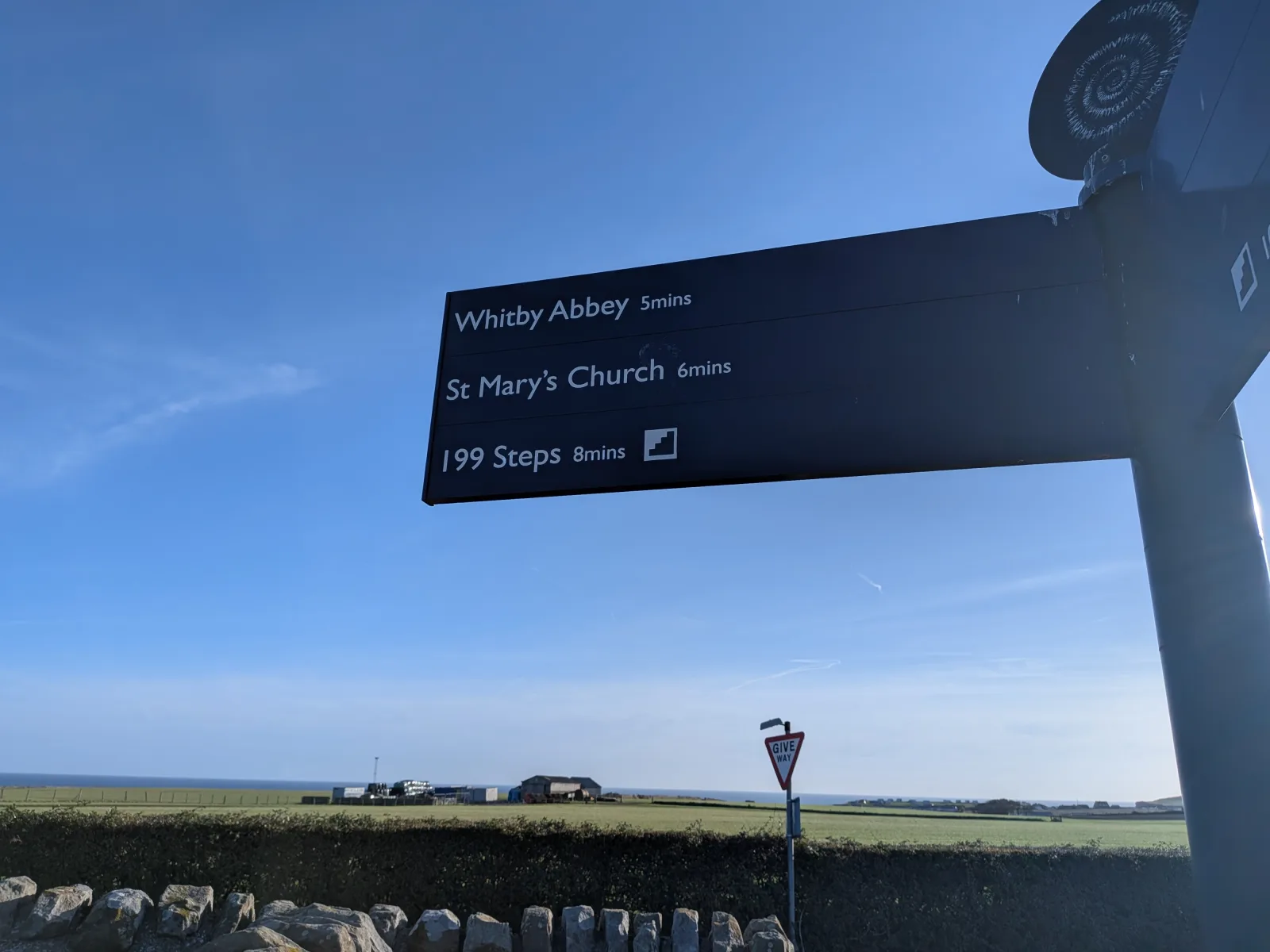 A signpost above Whitby pointing to Whitby Abbey and St Mary's Church